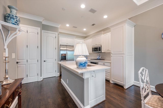 kitchen featuring a center island with sink, white cabinetry, light countertops, dark wood-type flooring, and appliances with stainless steel finishes