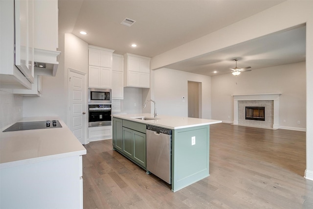 kitchen featuring ceiling fan, sink, green cabinets, white cabinetry, and stainless steel appliances