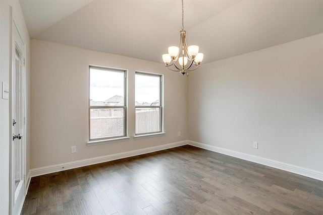 empty room featuring lofted ceiling, dark hardwood / wood-style flooring, and a notable chandelier