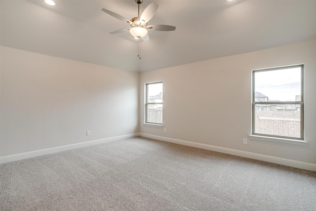 carpeted empty room with ceiling fan and lofted ceiling