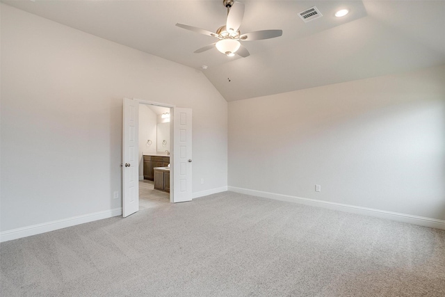 unfurnished bedroom featuring vaulted ceiling, ceiling fan, connected bathroom, and light colored carpet