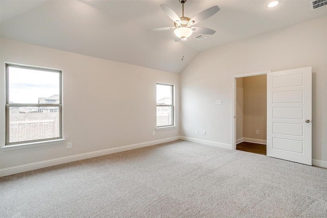 spare room with vaulted ceiling, ceiling fan, and carpet