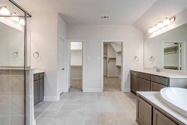 bathroom with vaulted ceiling, tile patterned floors, and vanity