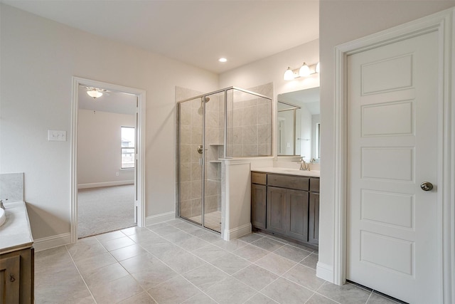 bathroom featuring a shower with shower door, vanity, and tile patterned flooring