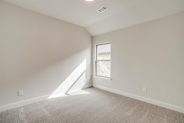 spare room featuring carpet floors and lofted ceiling