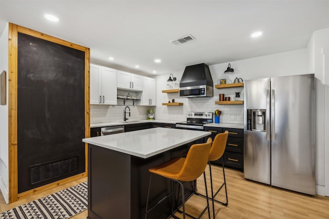 2905 Bilglade Rd, Fort Worth, TX 76133 - kitchen with stainless steel appliances, open shelves, ventilation hood, light wood-style flooring, and tasteful backsplash