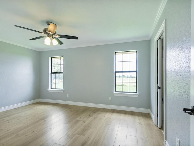 empty room featuring ceiling fan, light wood-type flooring, and ornamental molding