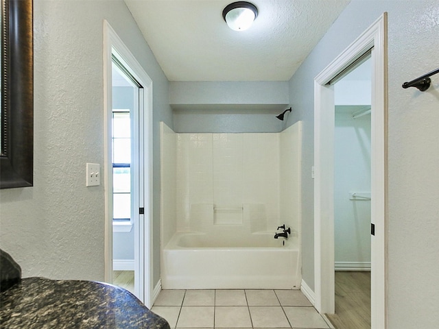 bathroom with tile patterned floors, a textured ceiling, and bathtub / shower combination