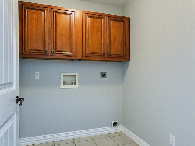 laundry area with electric dryer hookup, cabinets, light tile patterned floors, and hookup for a washing machine