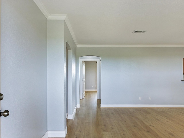 unfurnished room with light wood-type flooring and ornamental molding