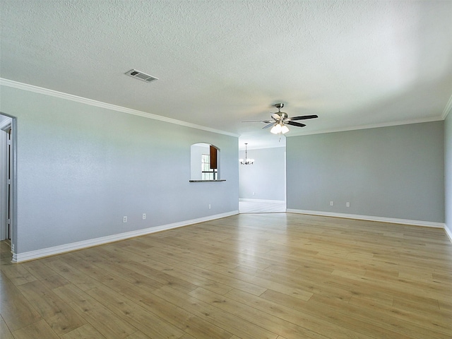 empty room with a textured ceiling, light wood-type flooring, ceiling fan, and ornamental molding