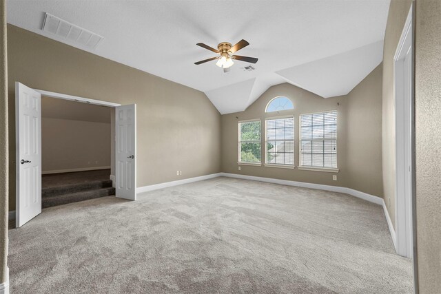 unfurnished bedroom with ceiling fan, lofted ceiling, and light carpet