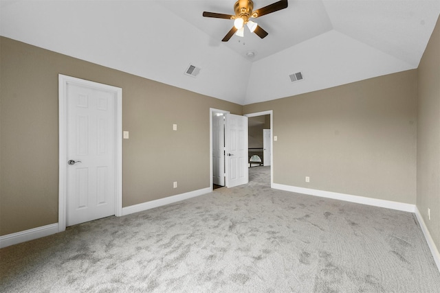 unfurnished bedroom featuring light colored carpet, vaulted ceiling, and ceiling fan