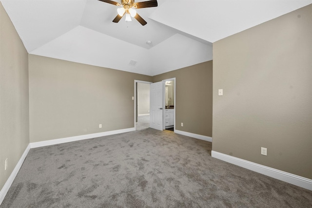 unfurnished bedroom featuring ceiling fan, a raised ceiling, carpet floors, and lofted ceiling