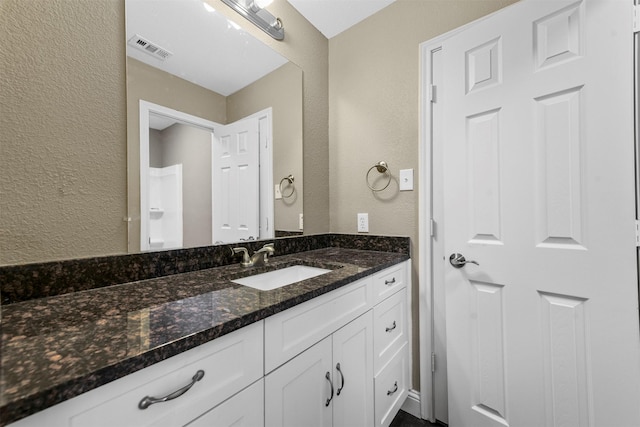 bathroom with vanity and a shower