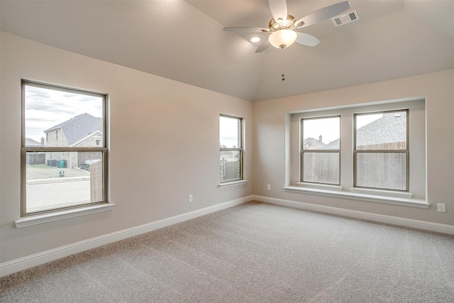 carpeted spare room with ceiling fan and vaulted ceiling