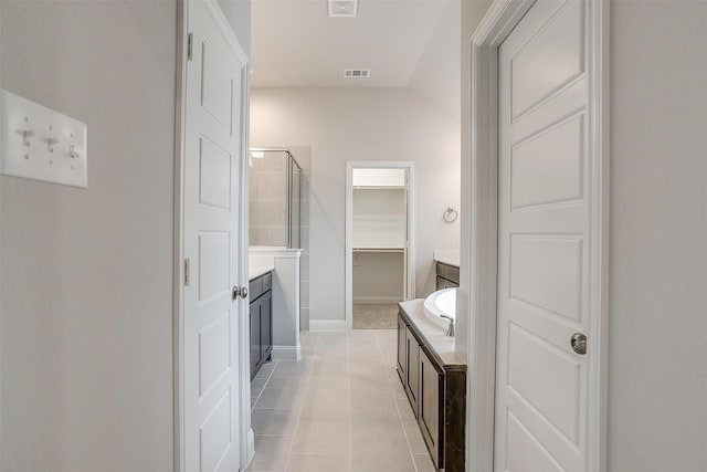 bathroom featuring tile patterned flooring, lofted ceiling, and shower with separate bathtub