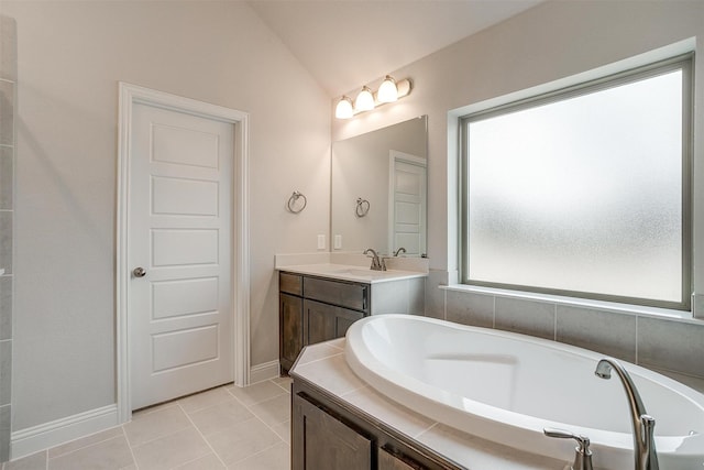 bathroom featuring vanity, vaulted ceiling, tile patterned floors, and a washtub