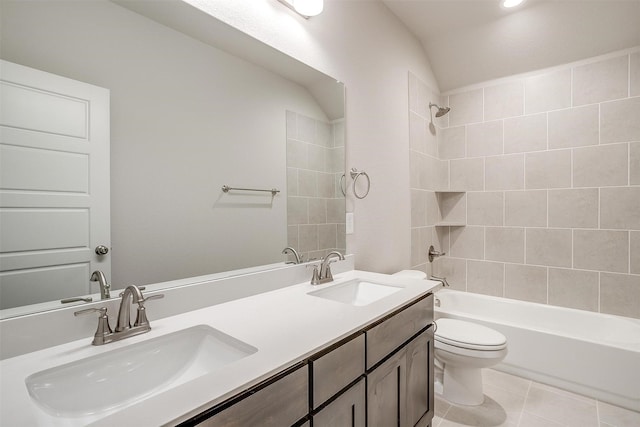 full bathroom featuring toilet, tiled shower / bath, vanity, lofted ceiling, and tile patterned floors