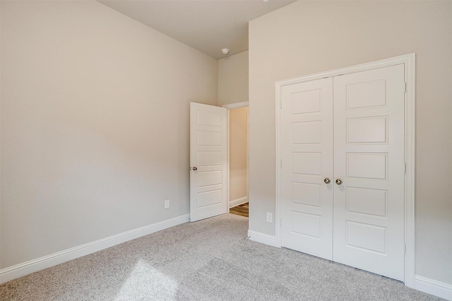 unfurnished bedroom featuring a closet and light colored carpet