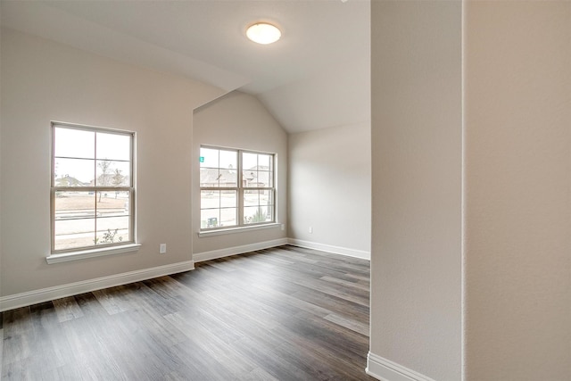 unfurnished room featuring lofted ceiling and dark hardwood / wood-style flooring