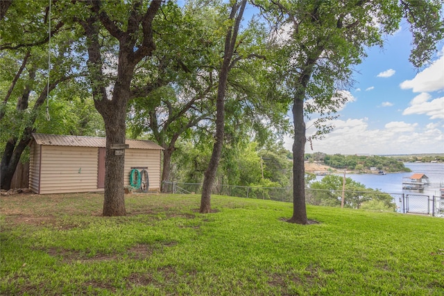 view of yard with a water view and a storage shed