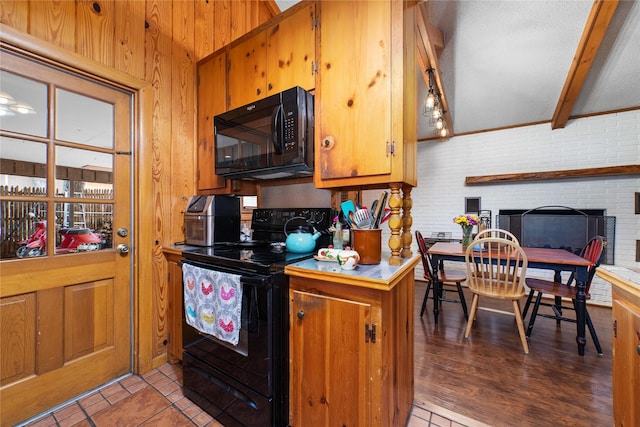 kitchen with beam ceiling, light tile patterned floors, and black appliances