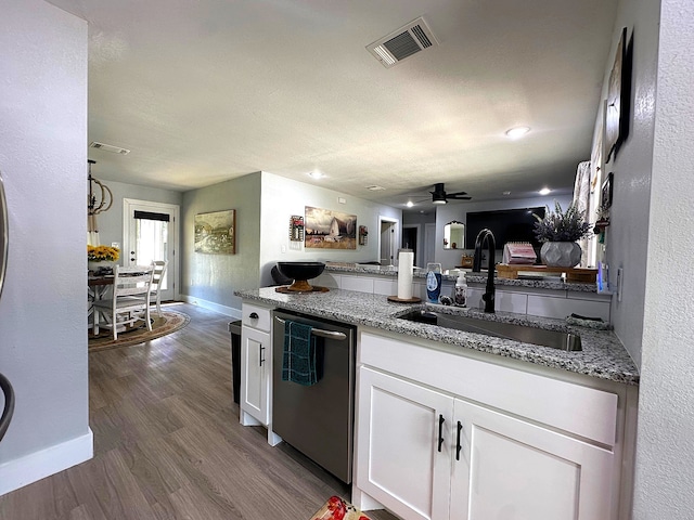 kitchen with light stone countertops, stainless steel dishwasher, dark wood-type flooring, white cabinets, and sink