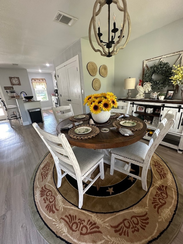 dining space with hardwood / wood-style floors and a chandelier