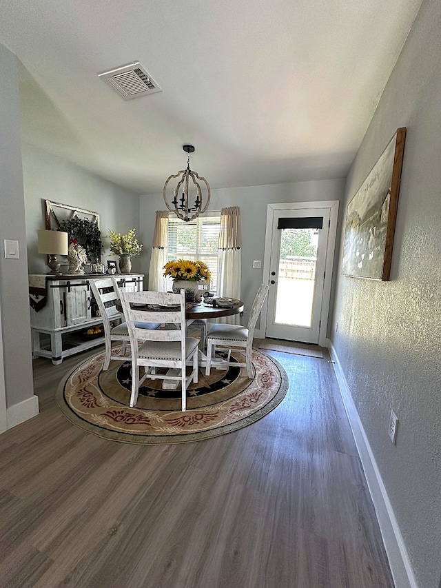 dining space featuring a notable chandelier and wood-type flooring