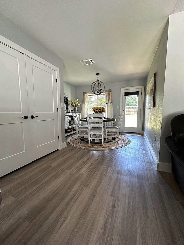 dining room featuring a notable chandelier and dark wood-type flooring