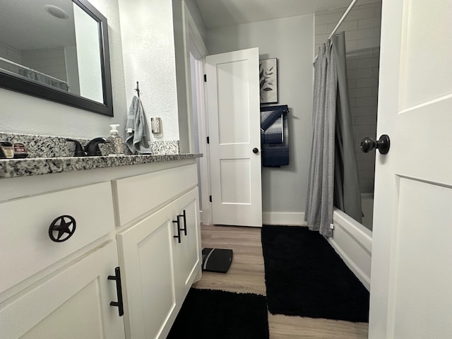 bathroom featuring shower / bathtub combination with curtain, vanity, and hardwood / wood-style floors