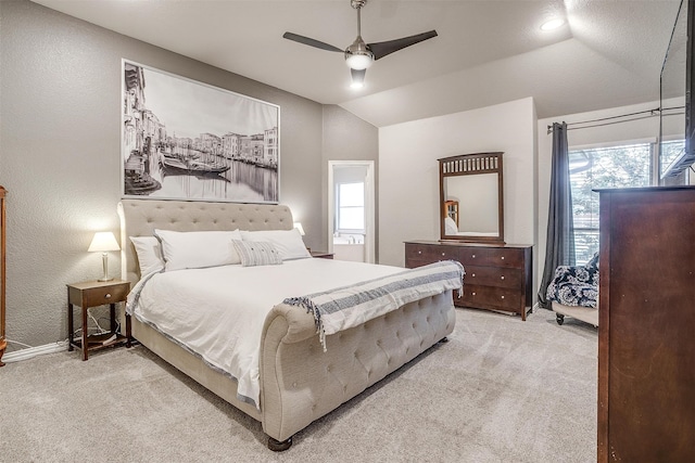 carpeted bedroom with a ceiling fan, lofted ceiling, and a textured wall