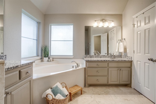 full bathroom with lofted ceiling, vanity, and a bath