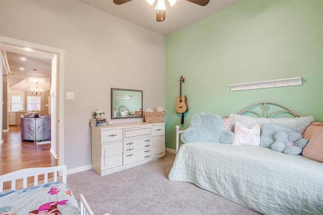 bedroom with carpet flooring, vaulted ceiling, baseboards, and ceiling fan with notable chandelier