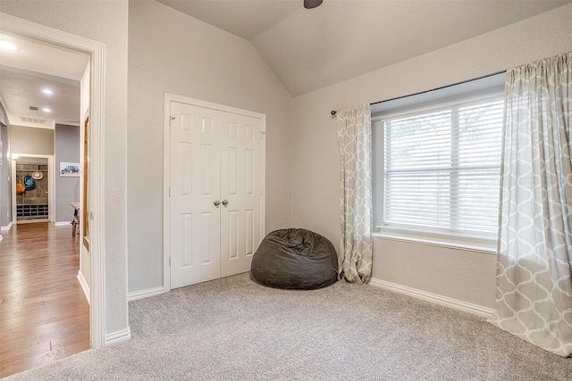 bedroom featuring lofted ceiling, a closet, and carpet flooring