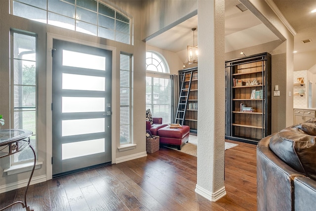 foyer entrance with wood-type flooring, visible vents, and baseboards