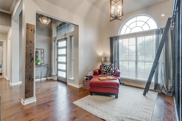 sitting room featuring a notable chandelier, dark hardwood / wood-style floors, and a high ceiling