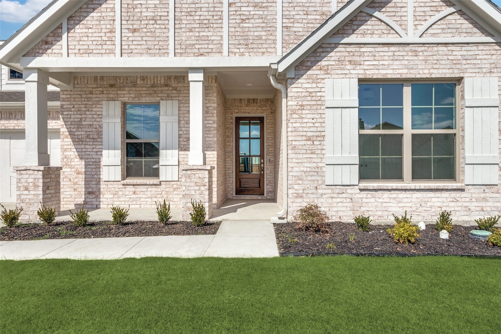 view of exterior entry featuring a yard