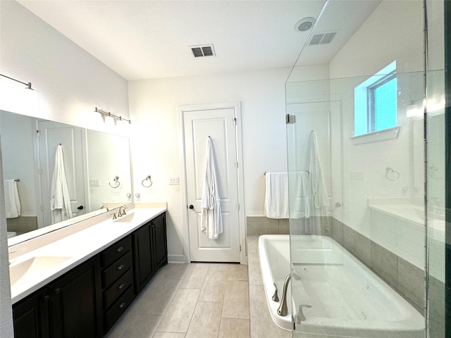 bathroom featuring double vanity, tile patterned flooring, and a tub to relax in