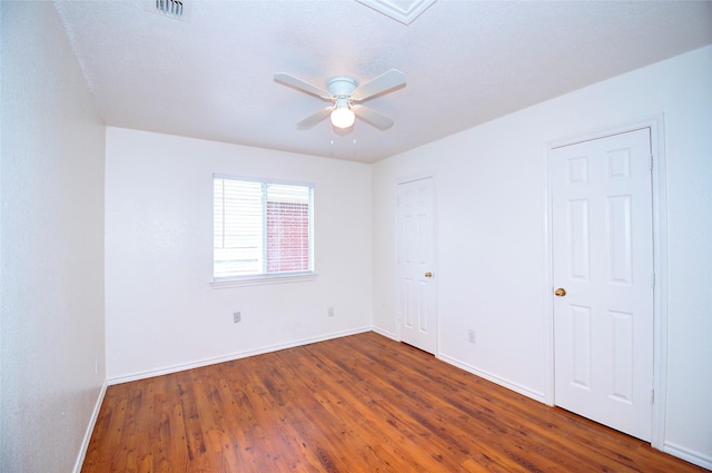 spare room with ceiling fan and dark wood-type flooring