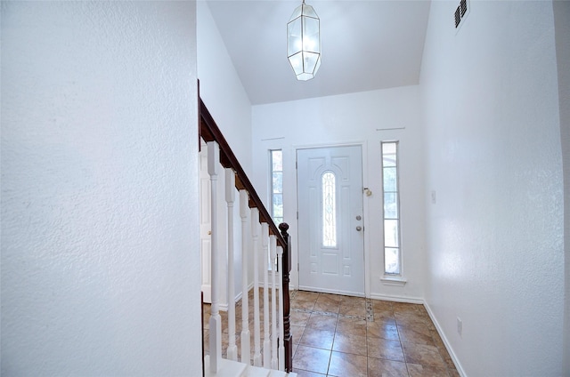 foyer entrance with tile patterned floors and a wealth of natural light