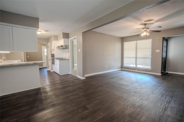 unfurnished living room with dark hardwood / wood-style floors and ceiling fan