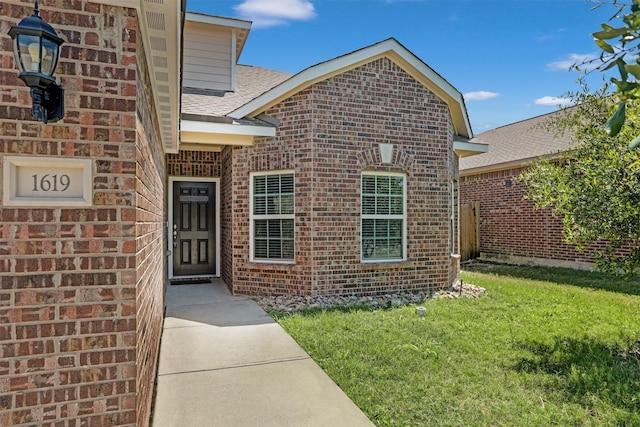 doorway to property featuring a lawn