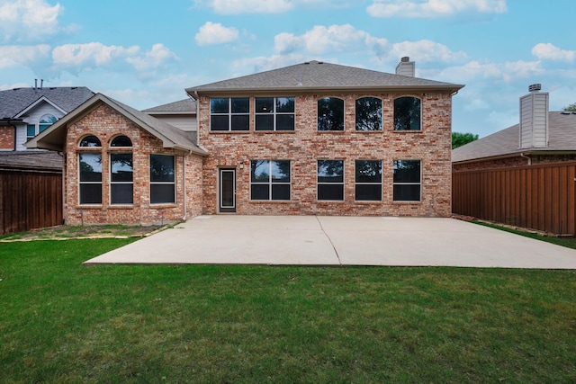 rear view of house with a patio and a yard