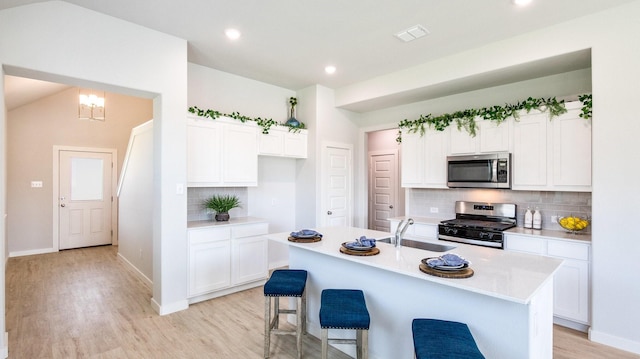 kitchen featuring a center island with sink, white cabinetry, sink, and appliances with stainless steel finishes