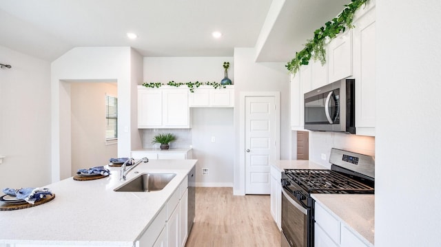 kitchen featuring decorative backsplash, white cabinetry, sink, and appliances with stainless steel finishes