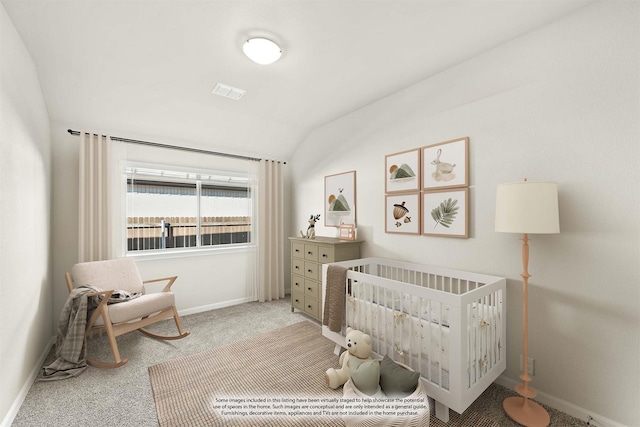 carpeted bedroom featuring a nursery area and lofted ceiling