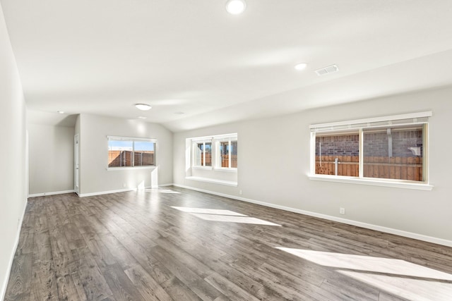 spare room with dark hardwood / wood-style flooring and vaulted ceiling