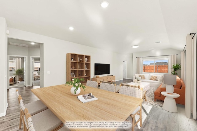 dining space featuring vaulted ceiling and hardwood / wood-style flooring